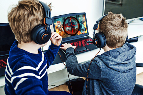 Deux petits garçons de dos jouent aux jeux vidéos