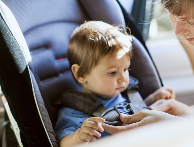 Maman attachant son enfant au siège auto