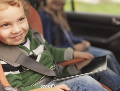 Enfant siège auto occupé avec une tablette tactile