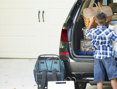 Enfant devant coffre à bagages voiture