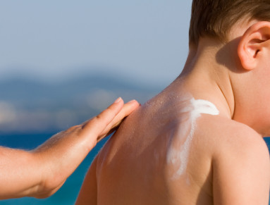 Enfant qu'on recouvre de crème solaire