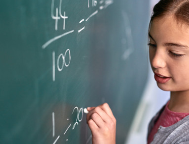 enfant qui écrit au tableau dans une classe