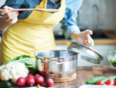 Une femme cuisine en tablier jaune