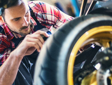 Un homme prépare sa moto pour l'hiver.