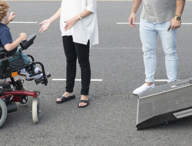 Un enfant handicapé monte dans sa voiture.