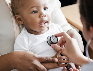 Un médecin écoute la respiration d’un bébé à l’aide d’un stéthoscope.