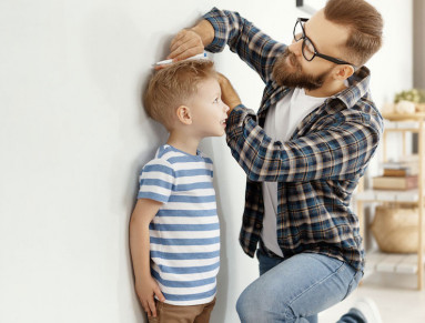 Des parents mesurent la taille de leur enfant.
