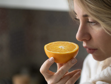 Une femme sent un bouquet une orange.