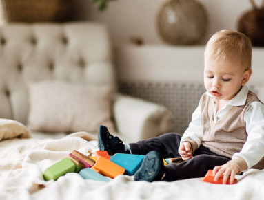 Un bébé joue sur un lit.