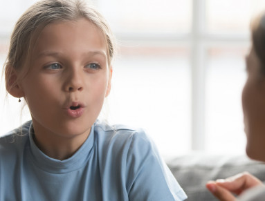 Une mère aide sa fille à s'exprimer.