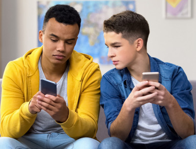 Deux jeunes sur leurs téléphones.