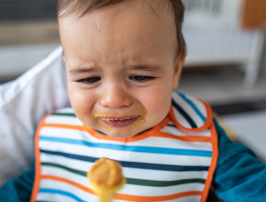 Une petite fille refuse de manger ses légumes.