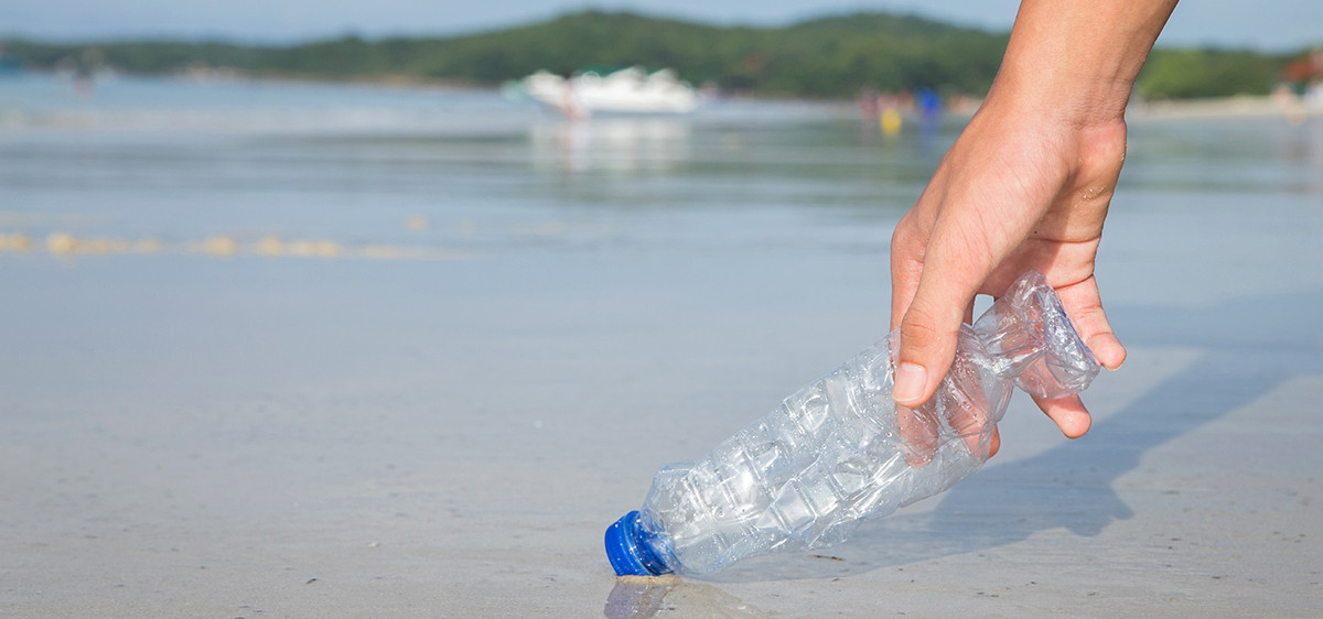 Ramasser une bouteille d’eau sur la plage.