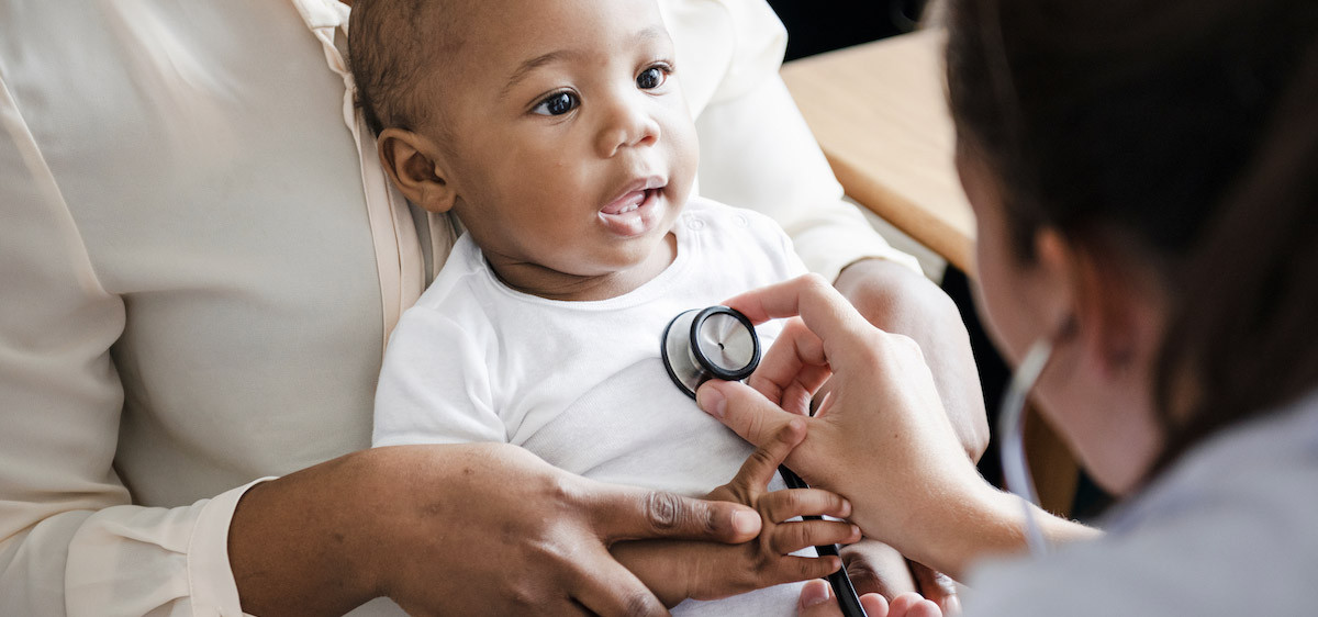 Un médecin écoute la respiration d’un bébé à l’aide d’un stéthoscope.
