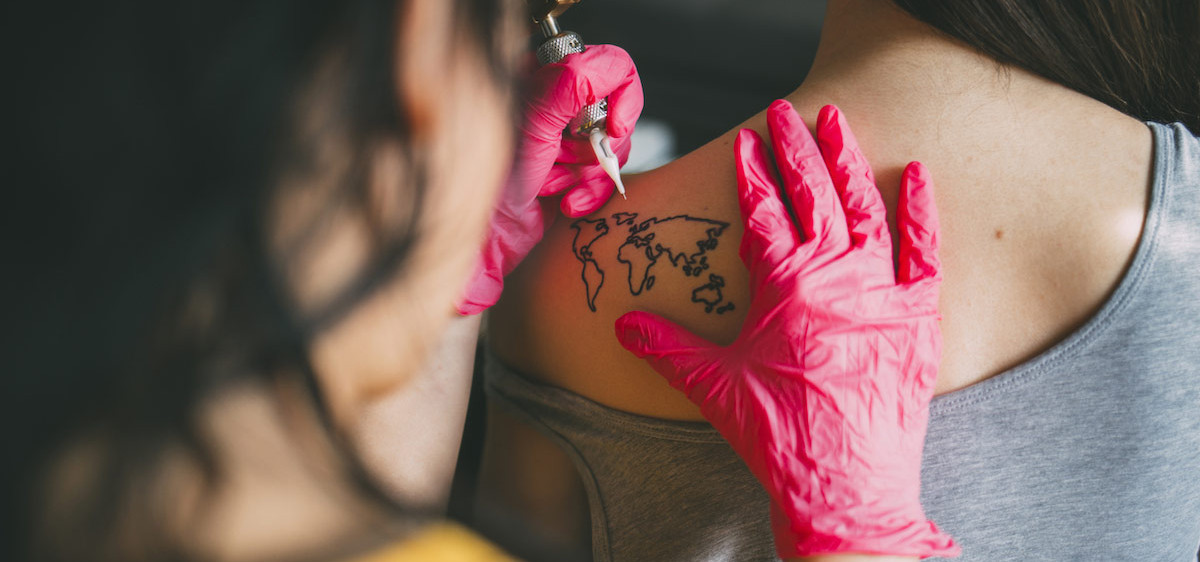 Une femme se fait tatouer le dos.