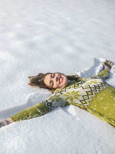 Femme heureuse couchée dans la neige